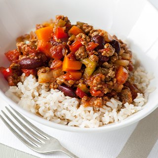 Vegetarian chilli with peppers, kidney beans and tomatoes served on a bed of rice in a bowl