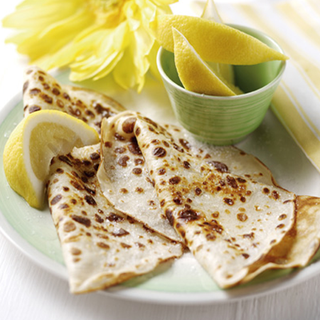 Crepe pancakes served with slices of lemon