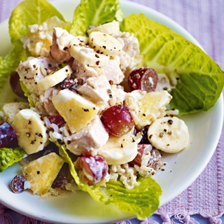 Salad consisting of lettuce, yoghurt, chicken, banana, pineapple, grapes and rice