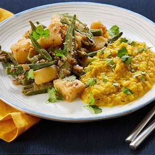 A plate of curried sliced okra and cubed potato, served with dhal