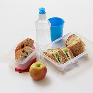 Quarters of sandwiches with a soft cheese, cucumber and lettuce filling, in a lunchbox