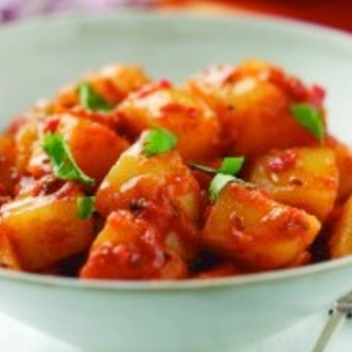 A serving of potatoes cooked with tomatoes and cumin