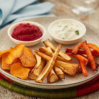 Slices of roast sweet potato, parsnip and carrot, served with dips