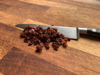 Raisins chopped into small pieces on a cutting board