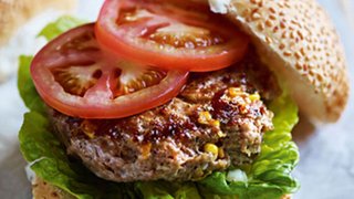 Image of a healthy turkey burger served in a whole grain bun with lettuce and tomato