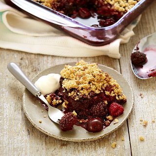 Cherry oat crumble served with a spoon of yoghurt