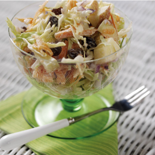 Shredded vegetables with apples and raisins, topped with a soft cheese dressing.
