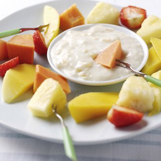 Chopped mango, strawberry, pineapple and papaya and a bowl of dip