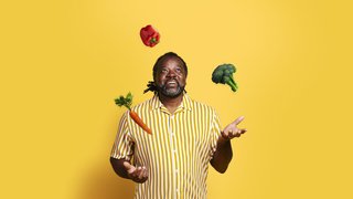 Man juggling fruit and vegetables