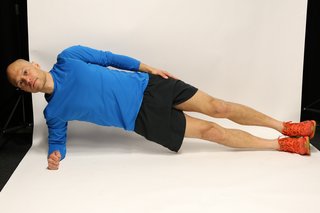 Man lying on side propped up on an elbow, with legs and hips raised in straight line from head to toe.
