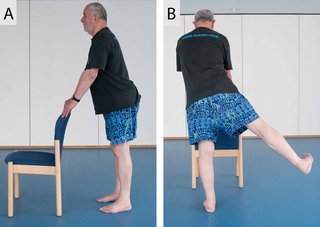 2 images showing someone doing a sequence of 2 different positions. The first image shows someone standing behind a chair with their hands on the back of the chair to support them. The second image shows someone lifting their right leg to the side, while keeping their hands on the back of the chair for support.