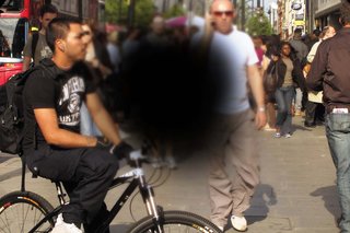 A busy street with a dark patch in the middle showing the loss of vision of someone with AMD.