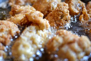 Close-up of some food covered in batter being fried in fat.